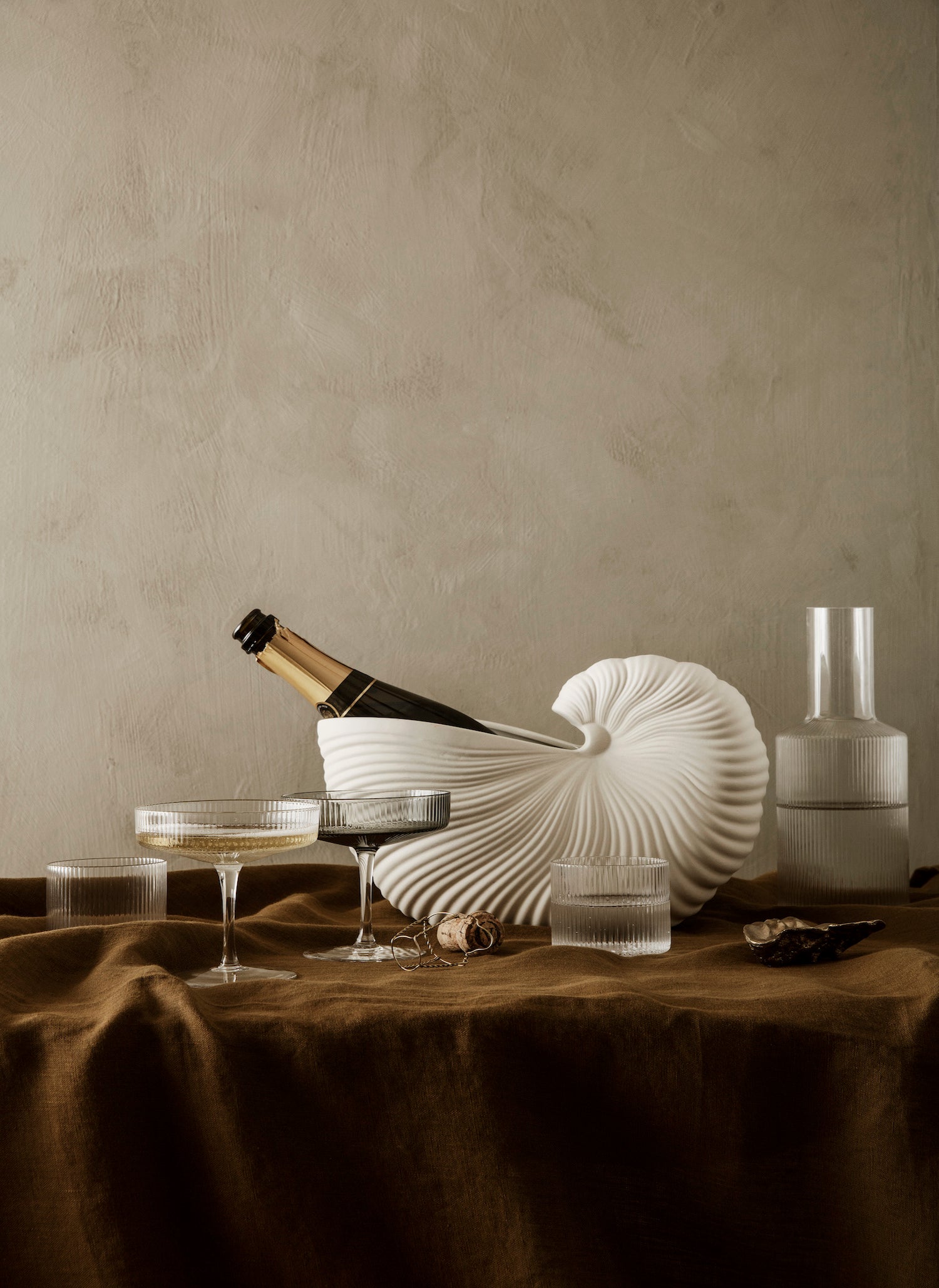 Ripple champagne coupes and shell pot on festive table.