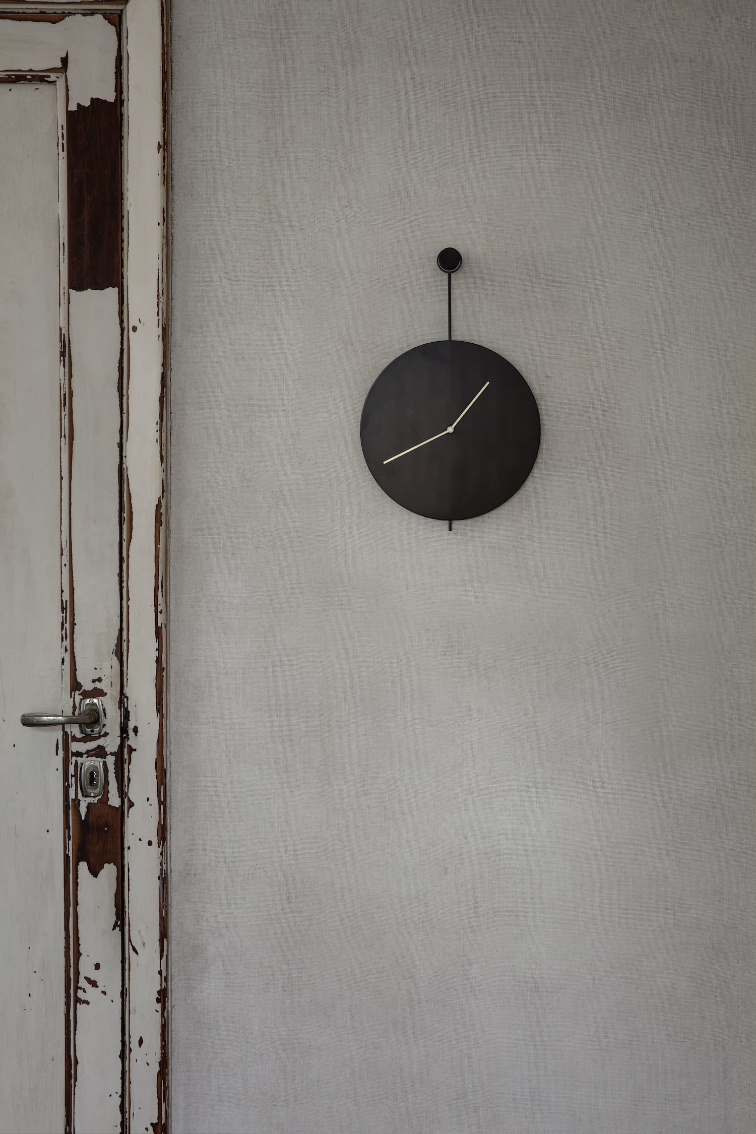 Trace Wall Clock. Minimalist, elegant wall clock with brass hands on a background of blackened steel, revealing only the constant, subtle movements of two hands reflecting the trace of time.
