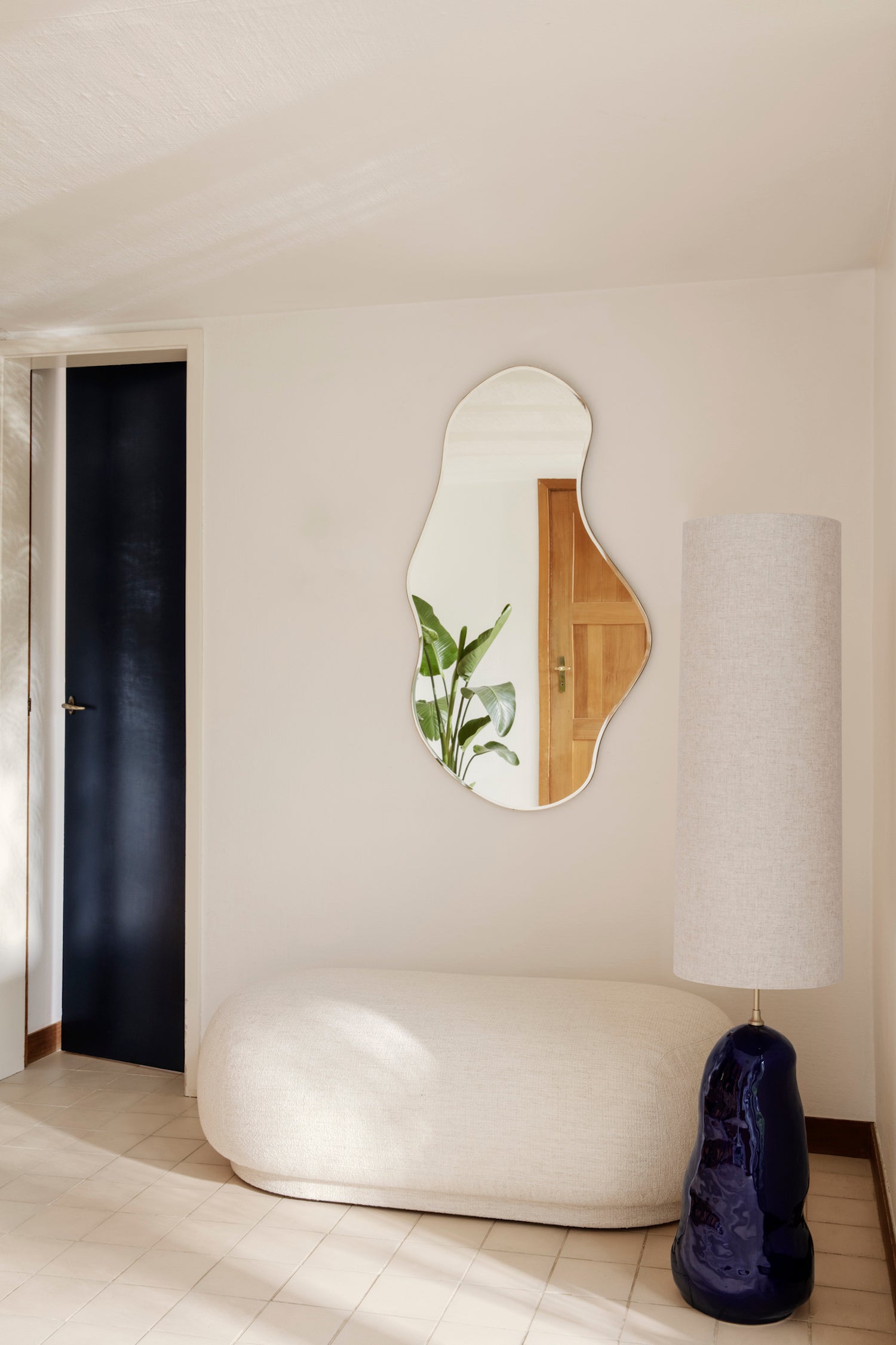 Dark Chrome Pond Mirror. Inspired by the movement of water, this inviting, open form wall mirror features a long, fluid shape with edges held by a slim, dark chrome frame.