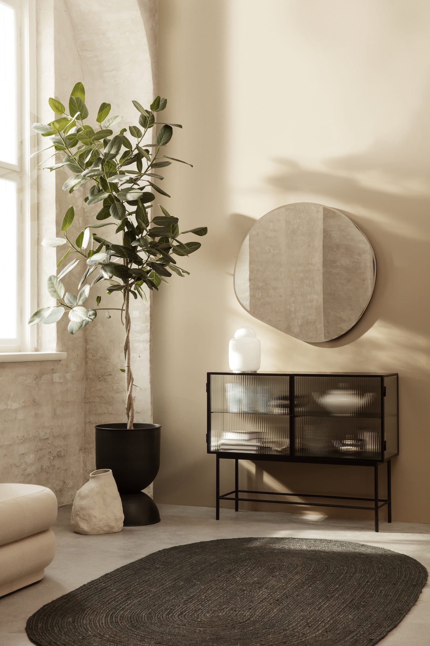 An inviting, open form wall mirror with a fluid, organic shape. Curved edges are held by a slim, dark chrome frame, and can be hung in any direction.