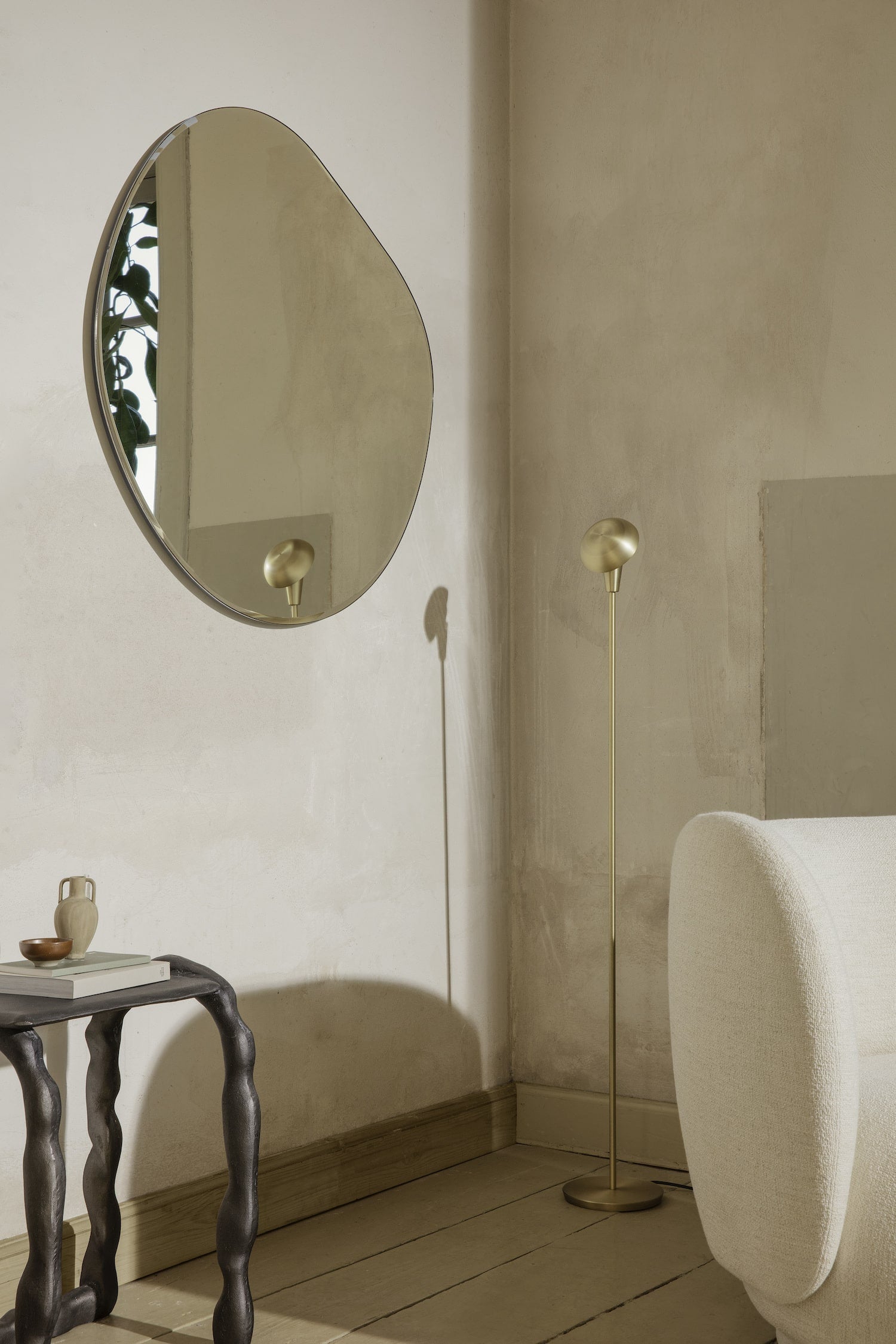 An inviting, open form wall mirror with a fluid, organic shape. Curved edges are held by a slim, dark chrome frame, and can be hung in any direction. 