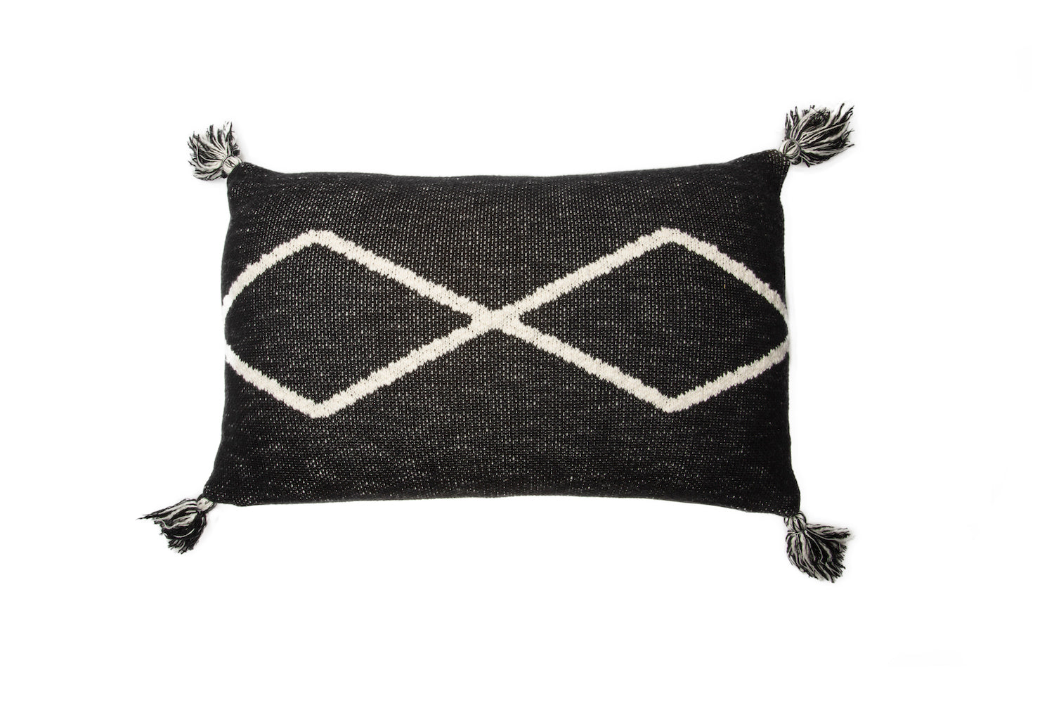 A soft knitted cushion in Black with rhombus pattern in natural and small corner tassels. 