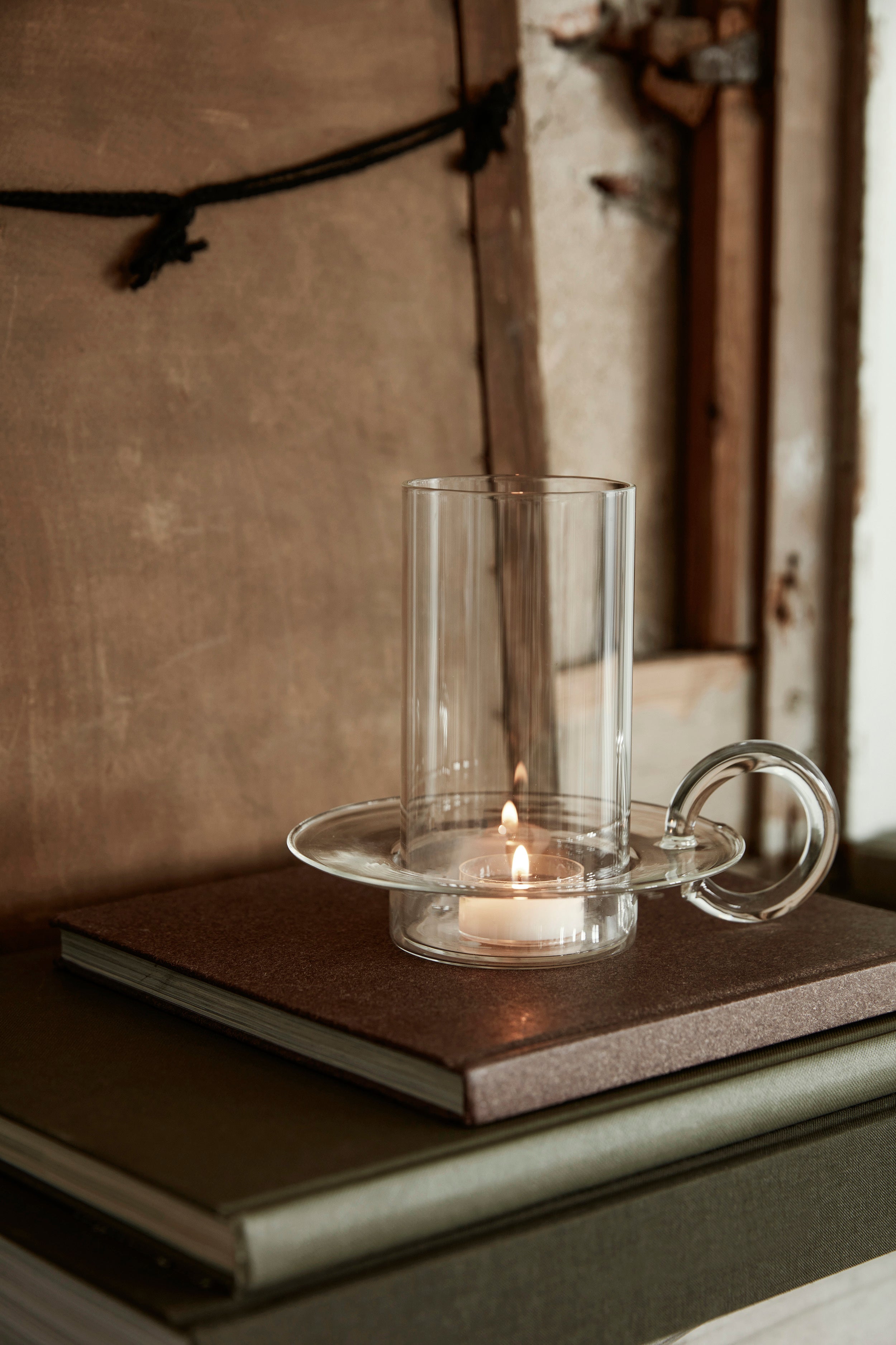 Luce Candle Holder is a modern take on antique candle holders, with transparent, heat-resistant glass version featuring a rounded handle and cylindrical base invites light and warmth into any space. 