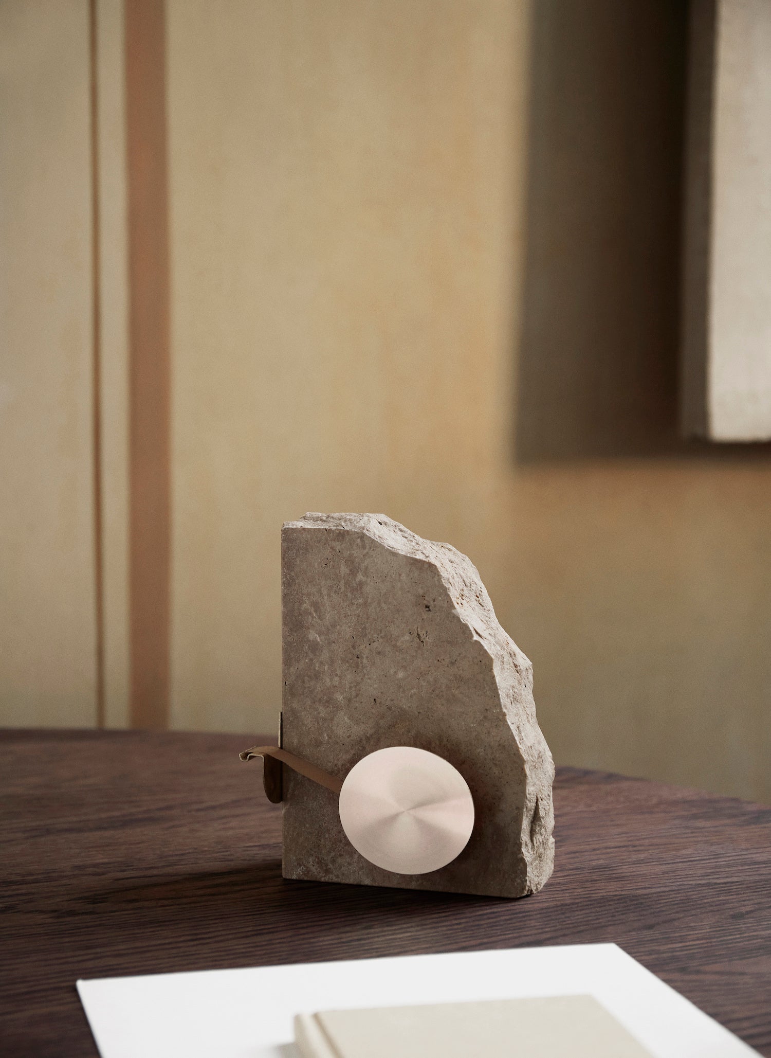 Klint Tape Dispenser. An elevated office accessory with a base made from travertine stone and functional tape dispenser features made of brushed brass. 