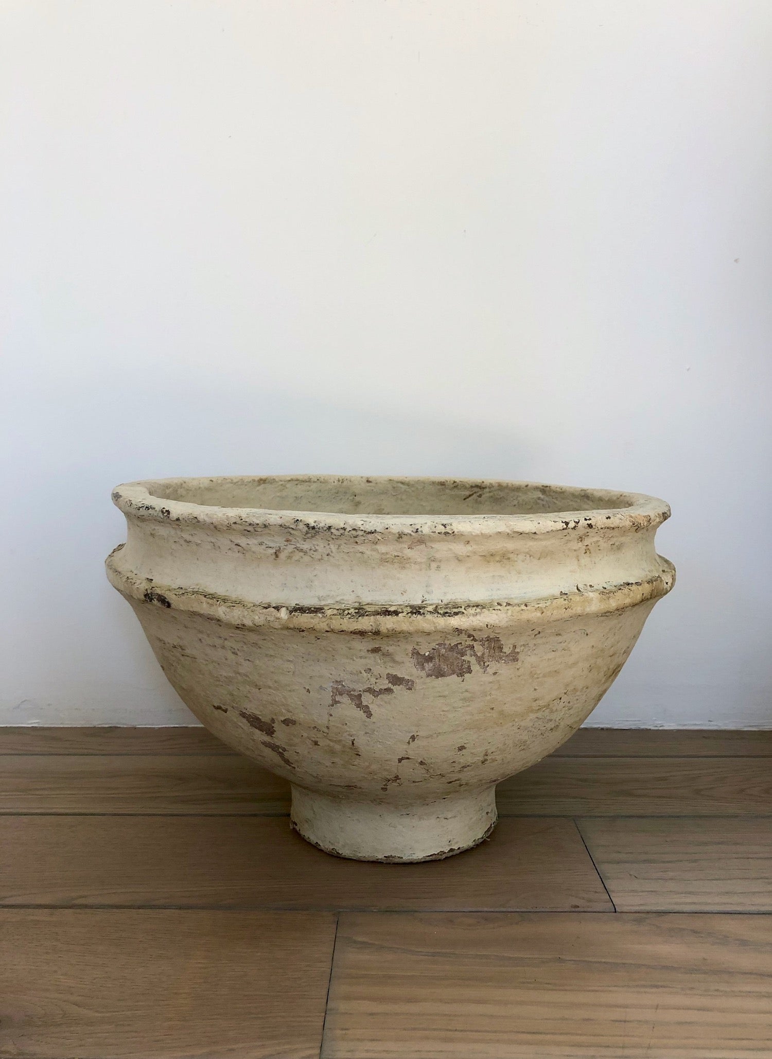 Oversized, hand crafted footed paper maché bowl with distinctive rim in a natural cream color.