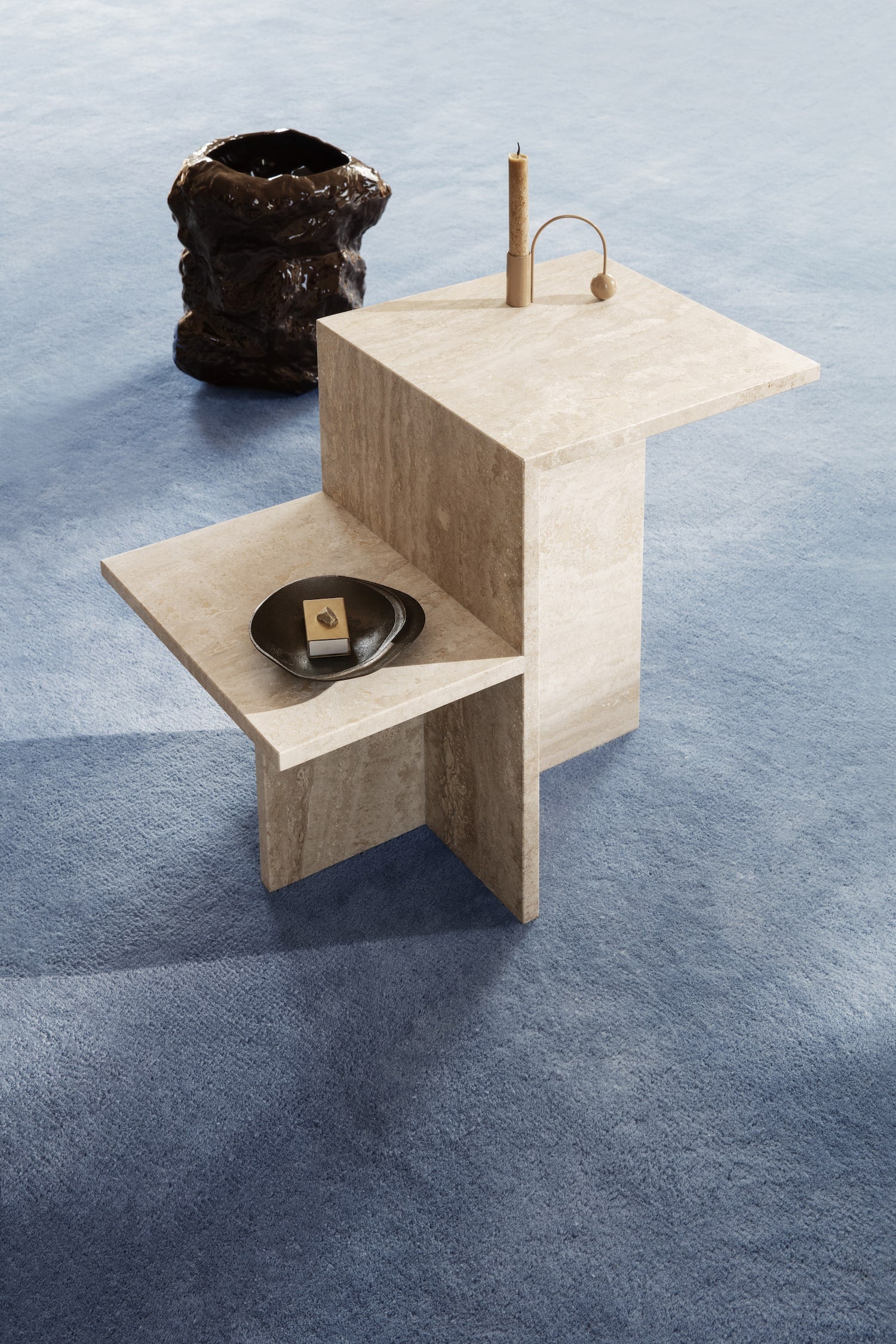 A minimalist and architectural side table made of natural sand-tone limestone by ferm LIVING. 