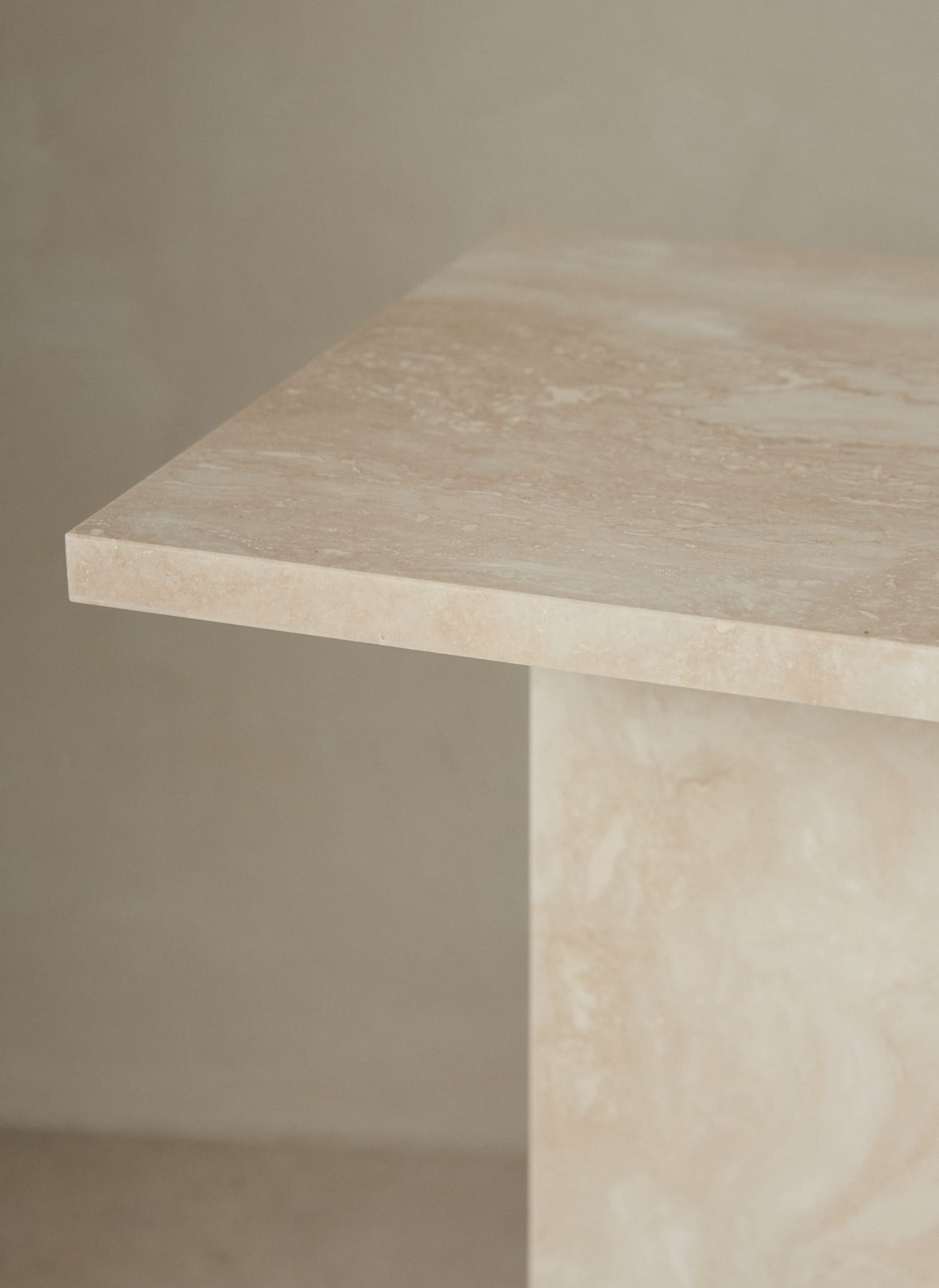 A minimalist and architectural side table made of natural sand-tone limestone by ferm LIVING. 