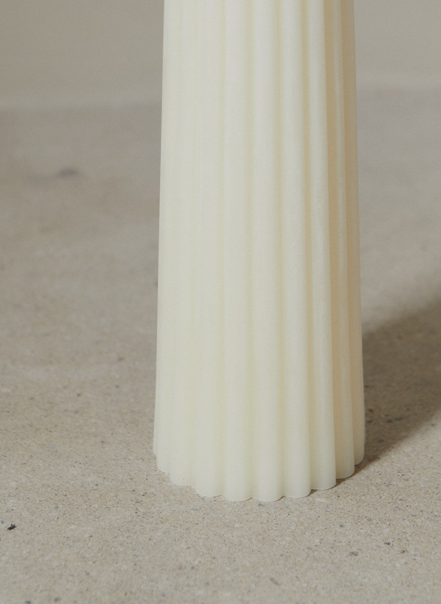View of ribbed texture at base of Greentree Home Cream Textured Pillar candle.