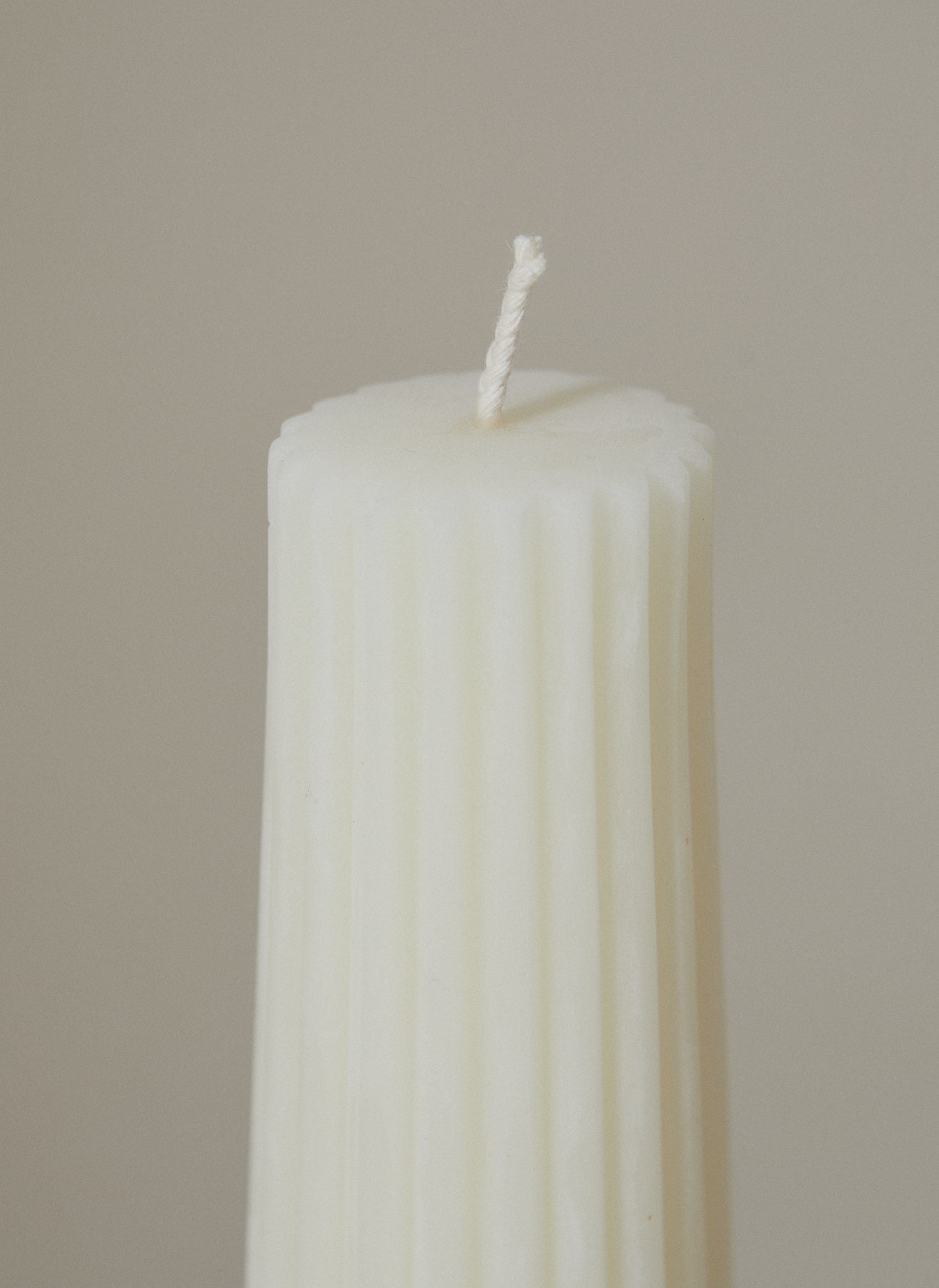 Close up of cotton wick on Greentree Home Cream Textured beeswax Pillar candle.