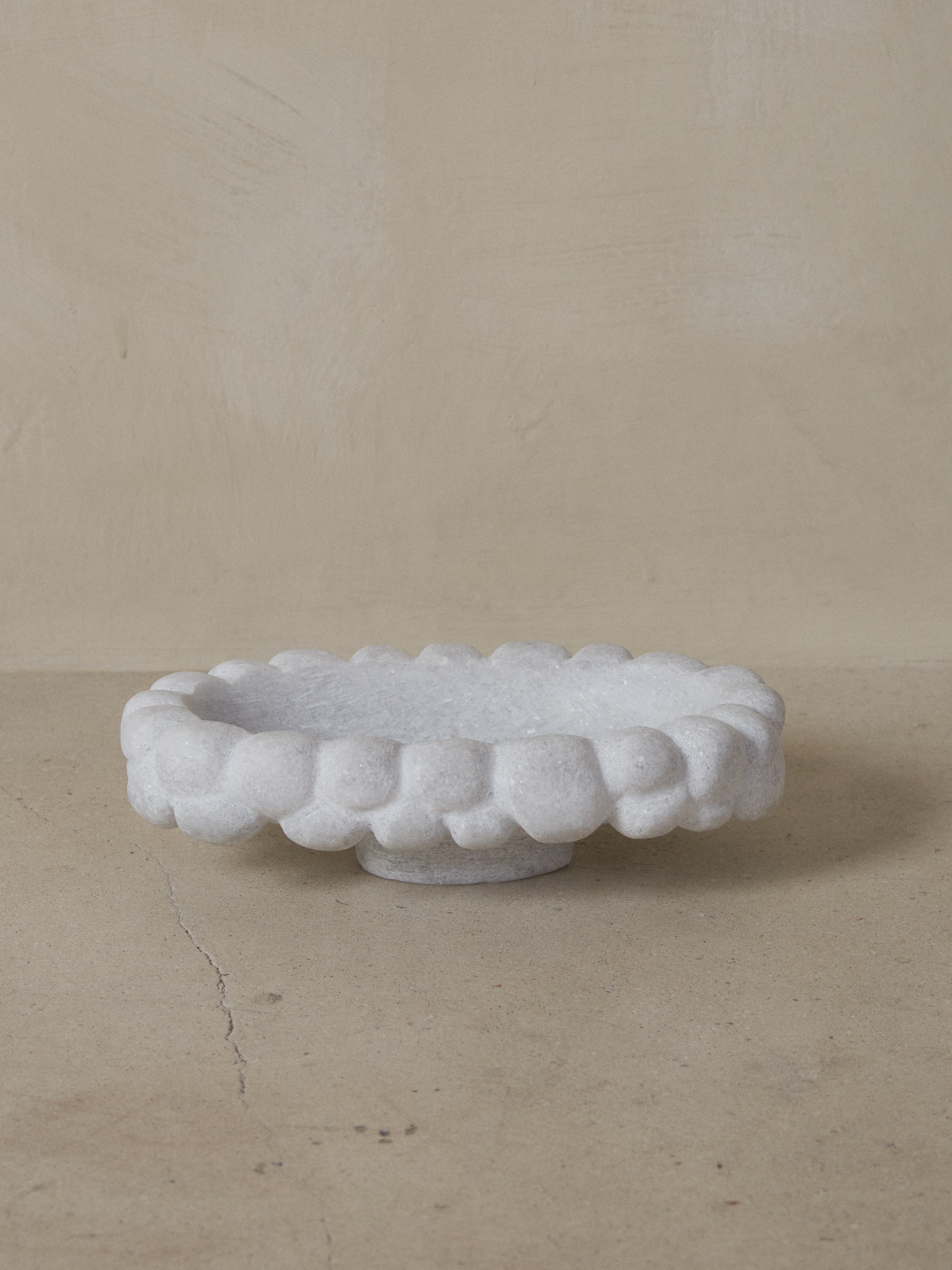 Crystalline Naxian marble hand sculpted into an oval footed bowl with a masculine, carved knotted edge and smooth interior. 