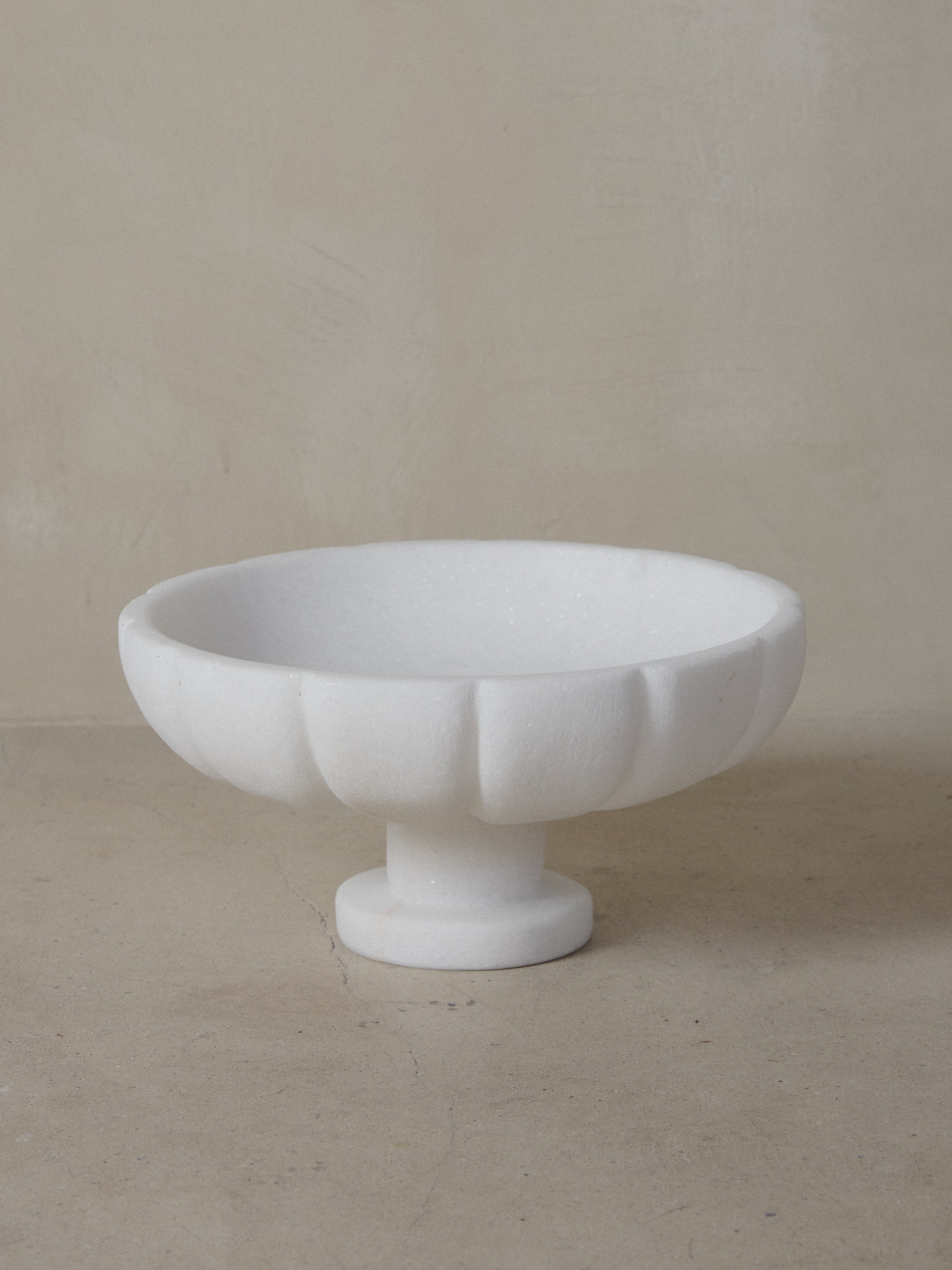Crystalline Naxian marble hand sculpted into an oversized, round footed bowl with smooth interior and elegantly carved paneled exterior.