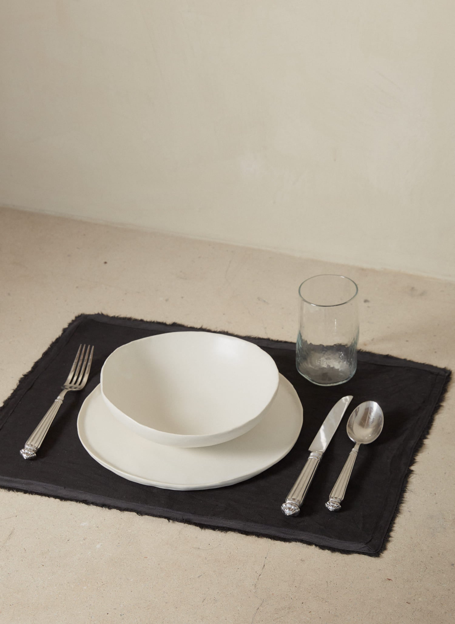 Casually elegant, rich black linen placemat with a fringe edge and tonal silk bias trim. 