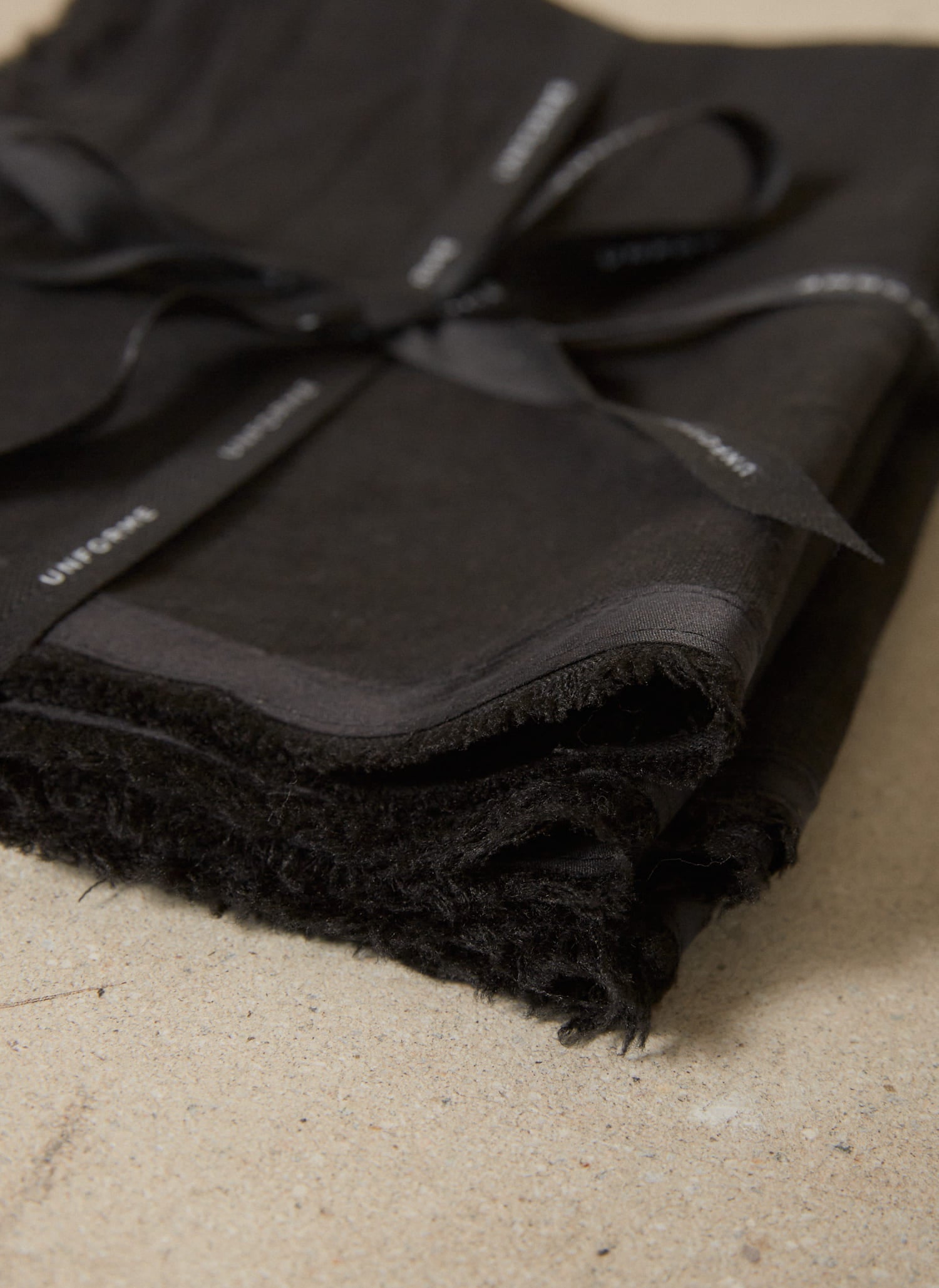 Casually elegant, rich black linen placemat with a fringe edge and tonal silk bias trim. 
