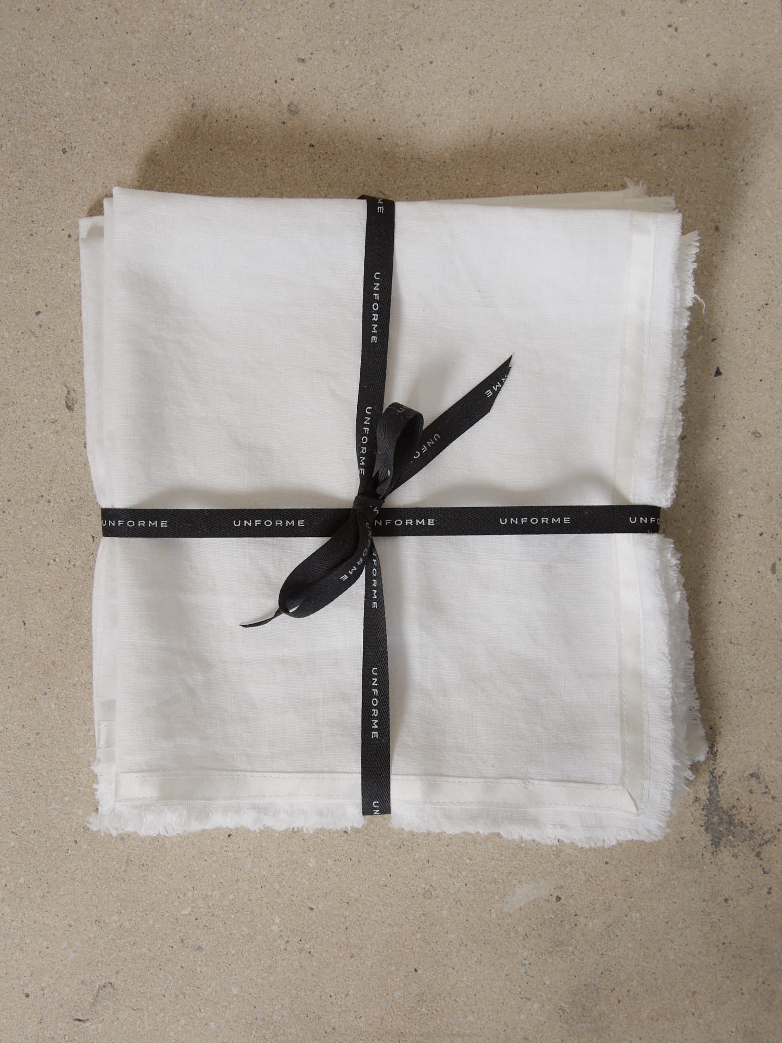 Casually elegant, crisp white linen napkin with a fringe edge and tonal silk bias trim.