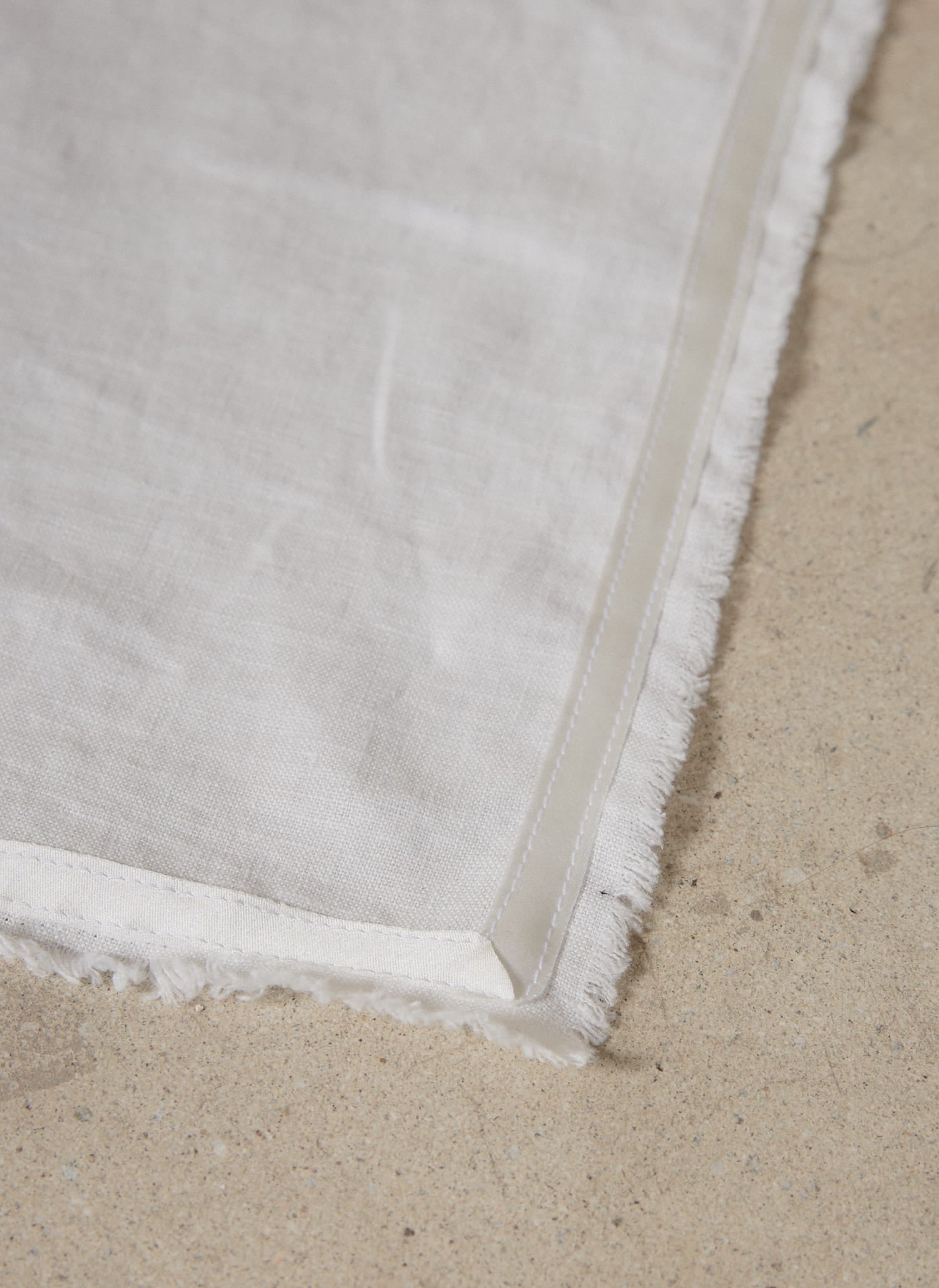 Casually elegant, crisp white linen napkin with a fringe edge and tonal silk bias trim.