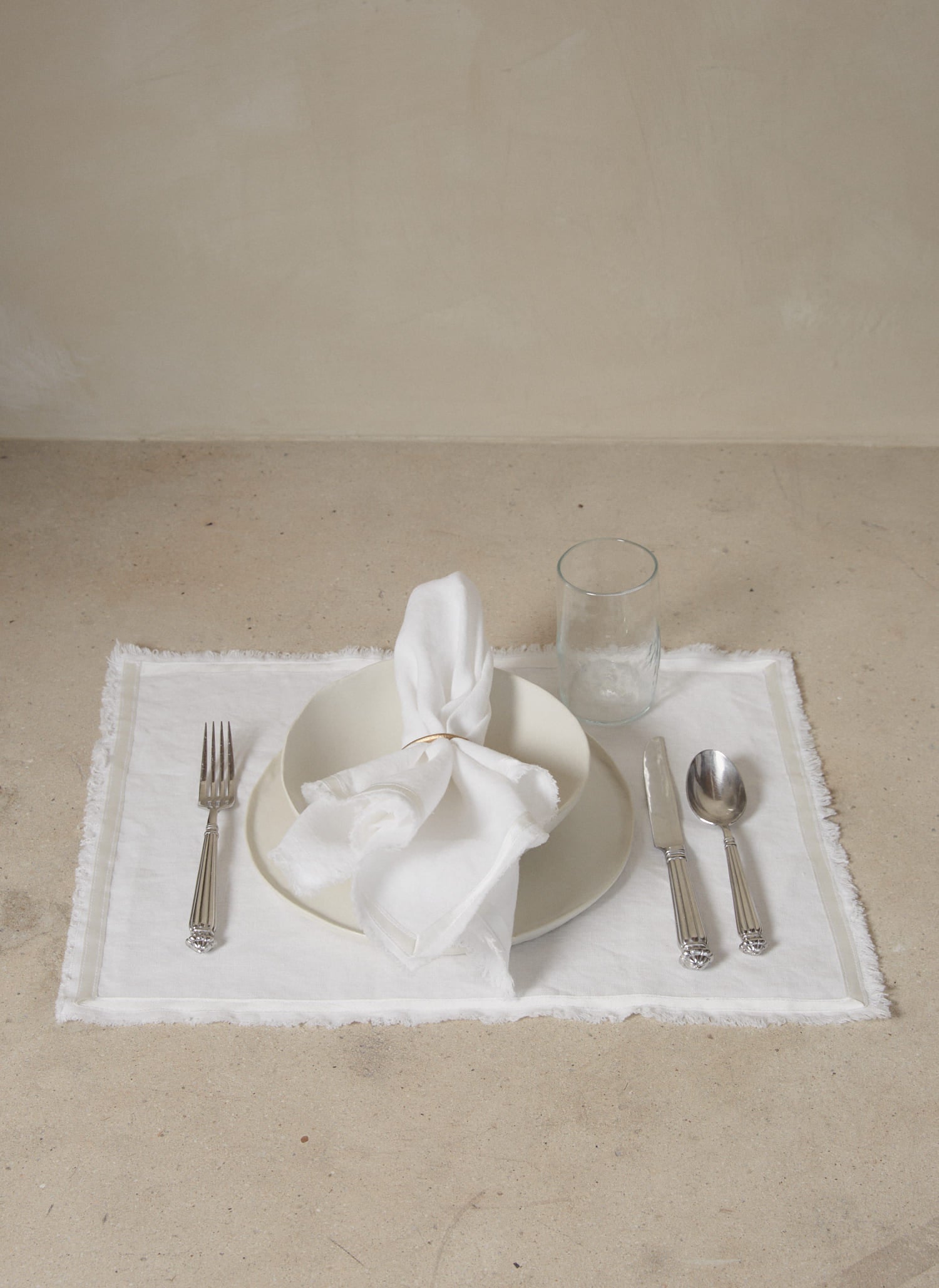 Casually elegant crisp white linen placemat with a fringe edge and tonal silk bias trim.