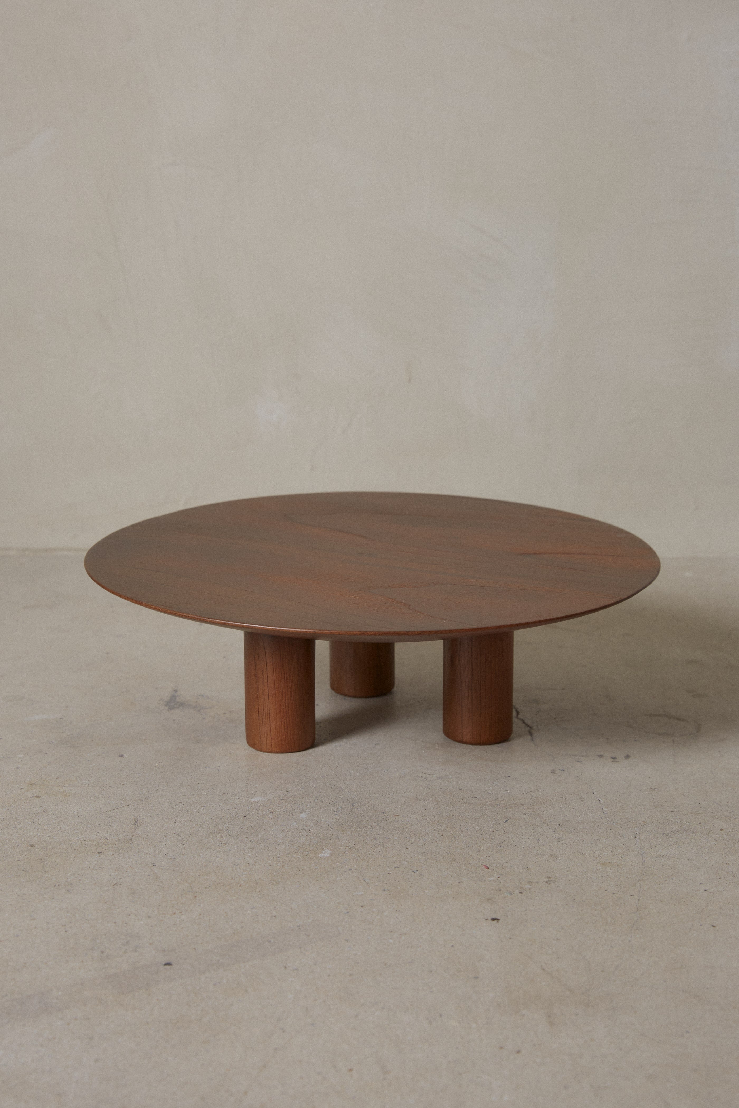  Modern and minimal round serving platter with three supporting legs and the markings of nature in deep, rich brown wood. 