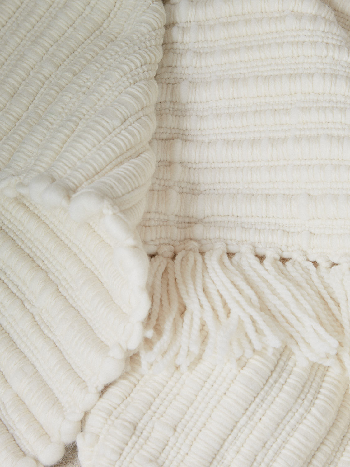 Aspen Blanket. A substantial, tactile and weighty statement throw blanket hand spun from the softest merino wool in an elegant, neutral cream color.