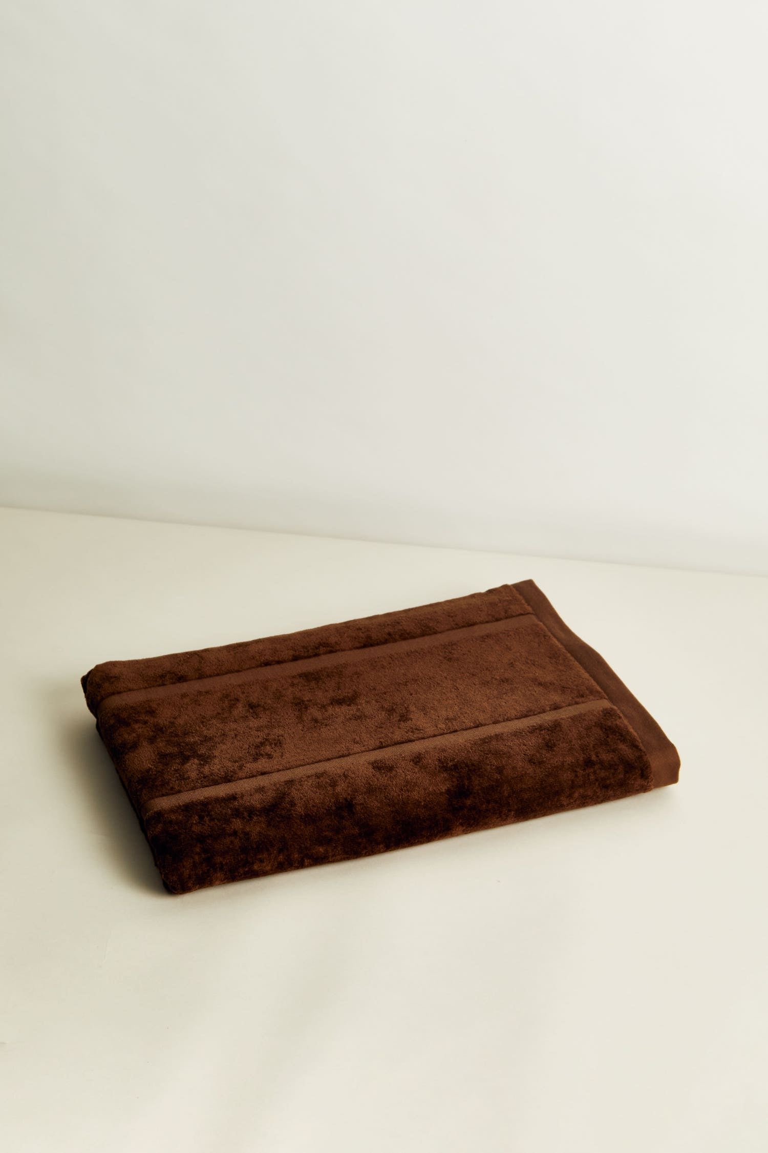 Woodford Organic Cotton Pool Towel in Tabac. An elevated, everyday bath, beach or poolside towel with a jacquard cut pile gate motif in brown with a luxuriously soft, 100% organic cotton hand. 