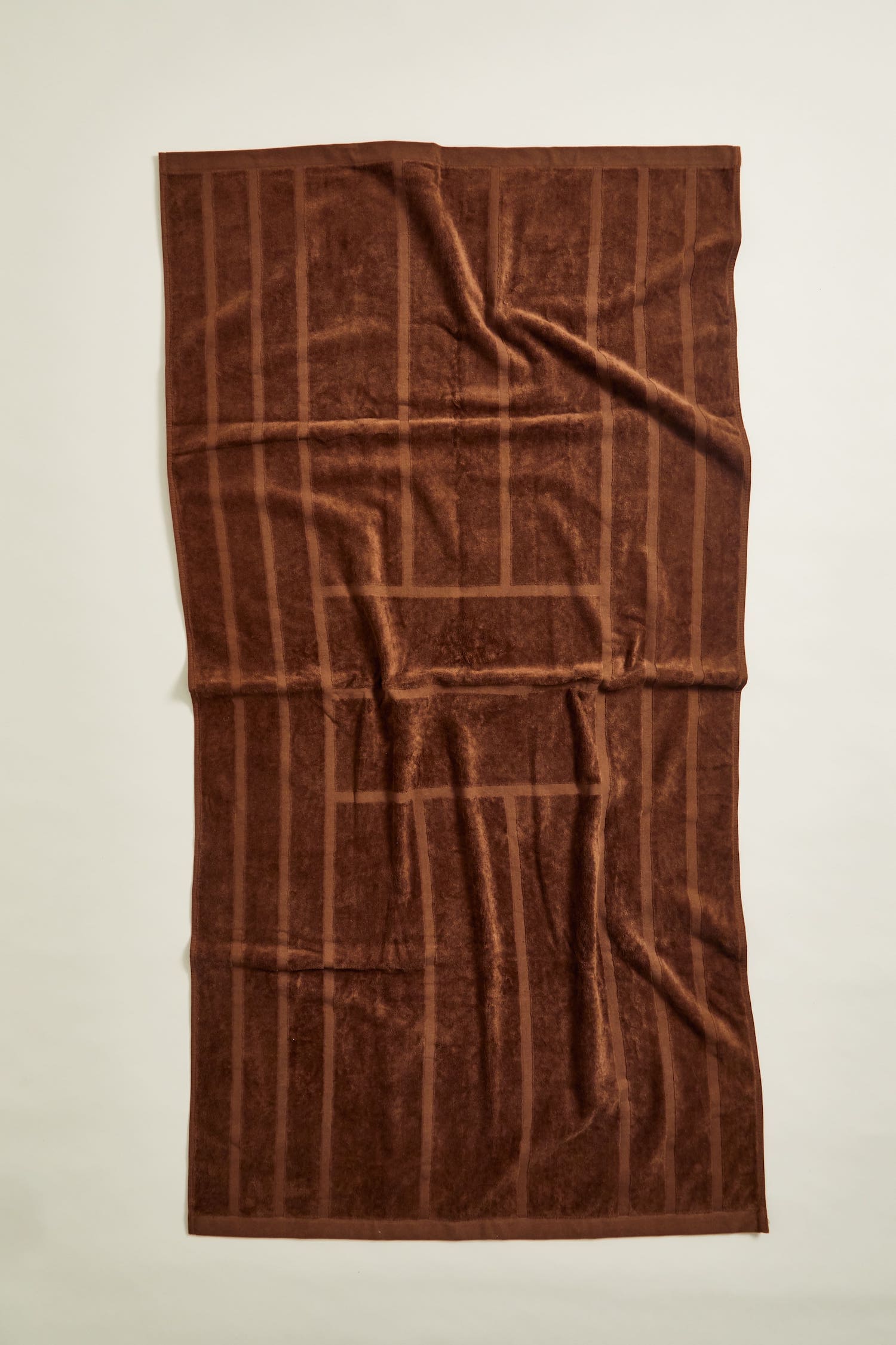 Woodford Organic Cotton Pool Towel in Tabac. An elevated, everyday bath, beach or poolside towel with a jacquard cut pile gate motif in brown with a luxuriously soft, 100% organic cotton hand.