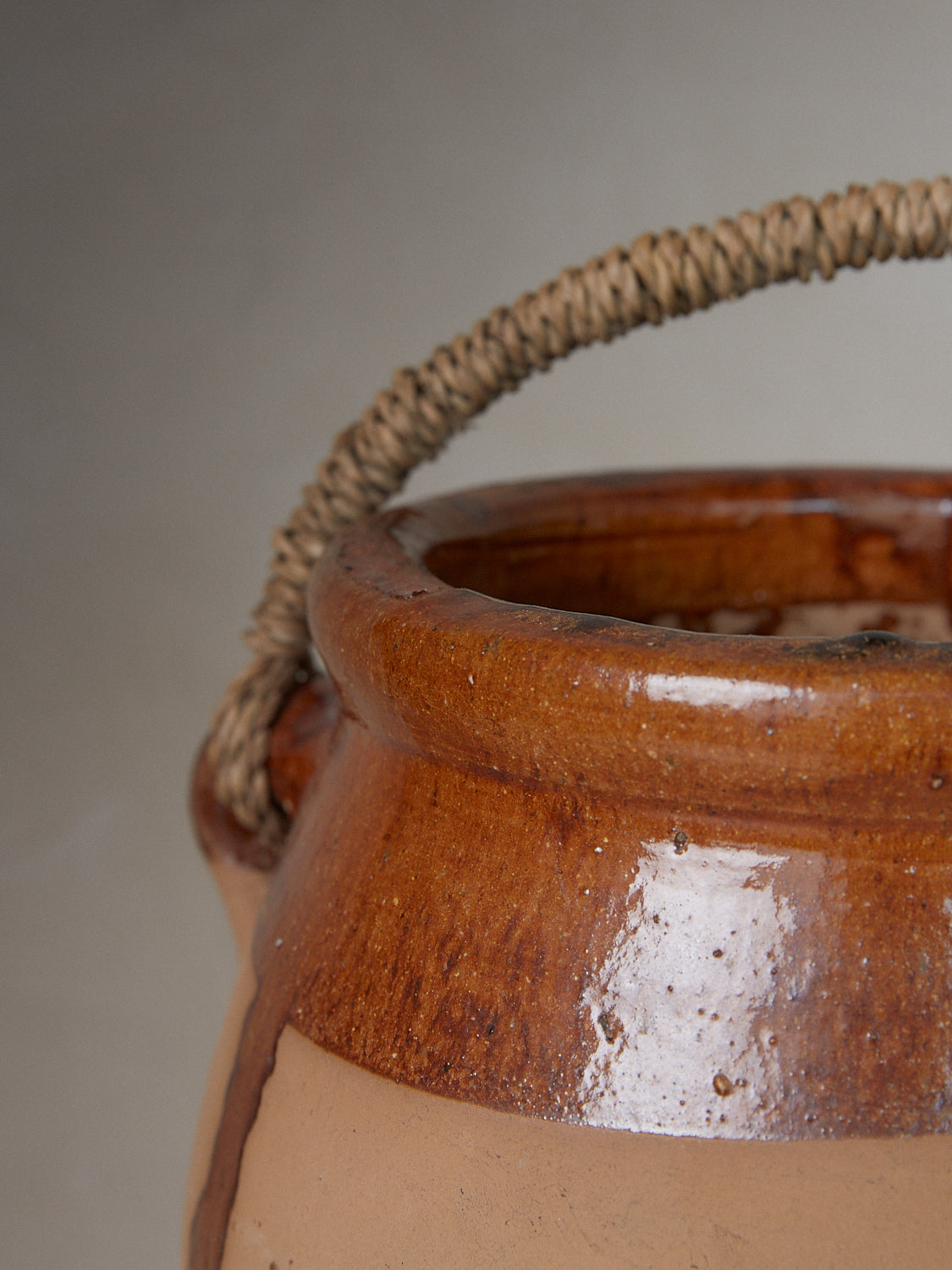 Mouraz Vessel. Rare vintage find. Tall, rustic earthenware vessel with ribbed detailing at bodice, a mixed glaze finish, high side handles and woven raffia top handle.