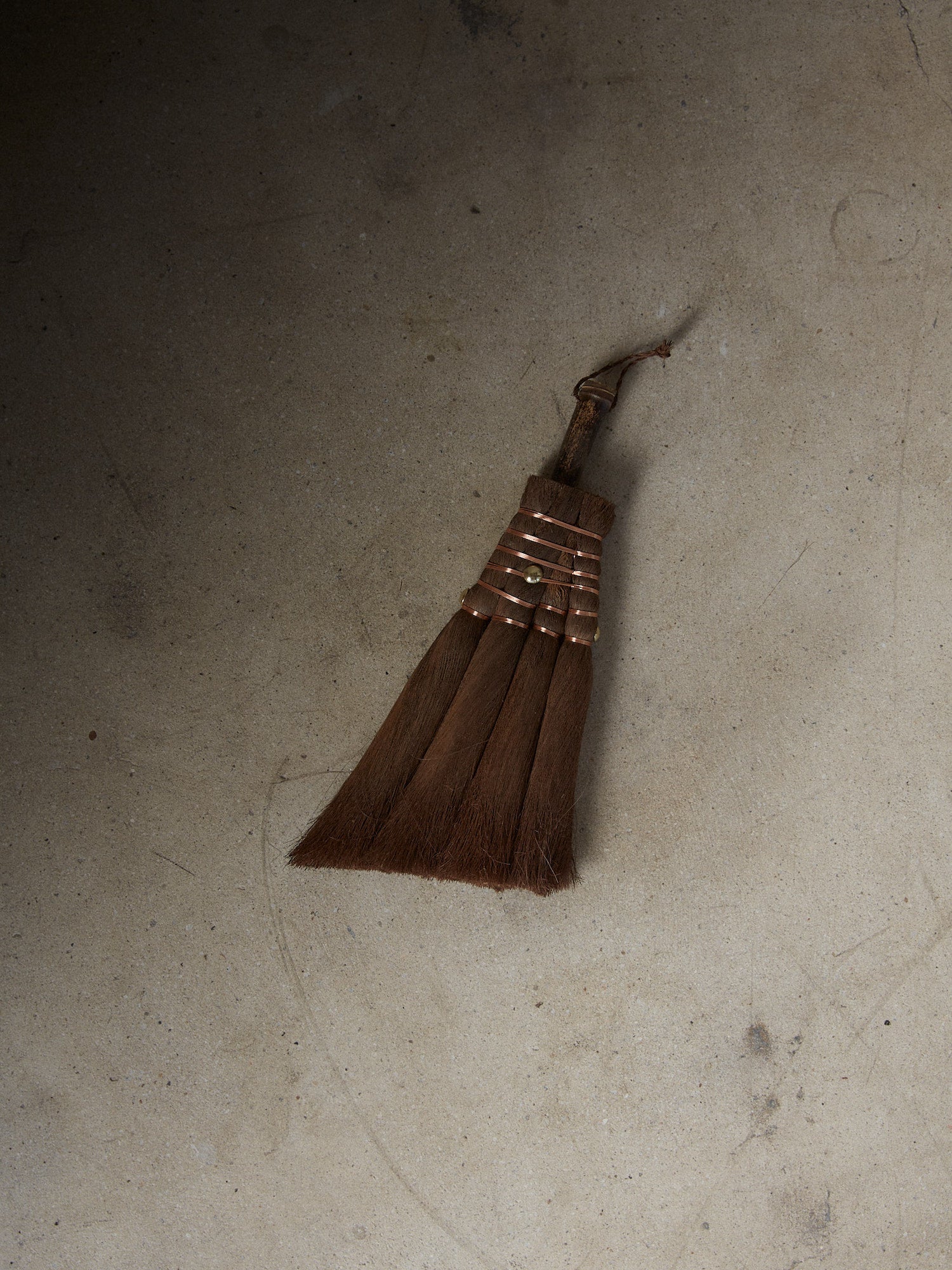 Angled Vintage Hand Broom. Rare find. Natural hand held broom with a short bamboo handle hand crafted of fine Indian Palm fibers and joined by copper wire for a light, clean sweep.