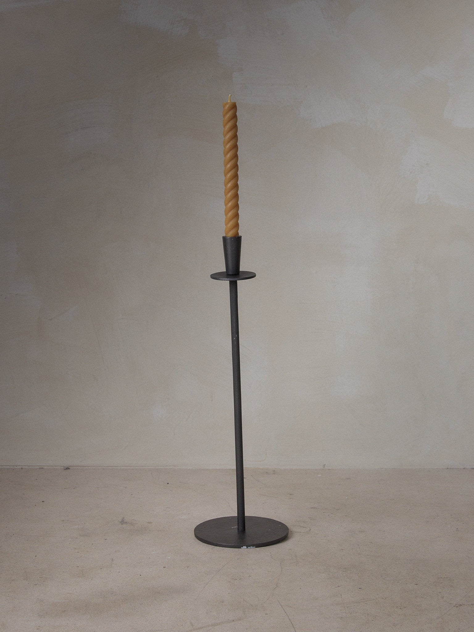 Hoy Casted Candle Holder. Tall, slim, elegant candle holder in black cast aluminum with a raw, matte finish.