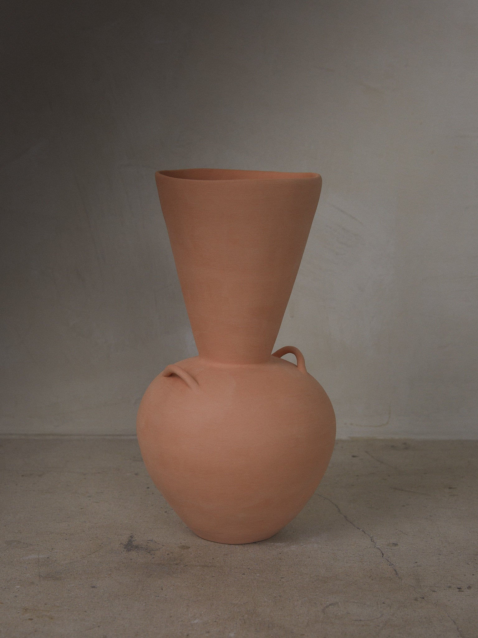 Terracotta Vase. Handmade terracotta vase with low, rounded bodice, stately neck and decorative side handles created with a modeling technique featuring traces of the artistic process.