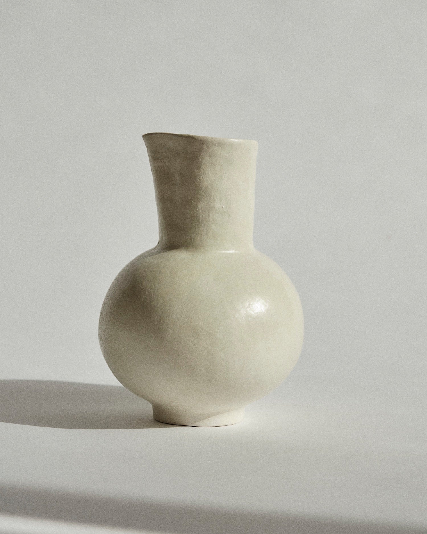 Water Pitcher. Footed stoneware jug with wide, rounded bodice and narrow, spouted neck.
