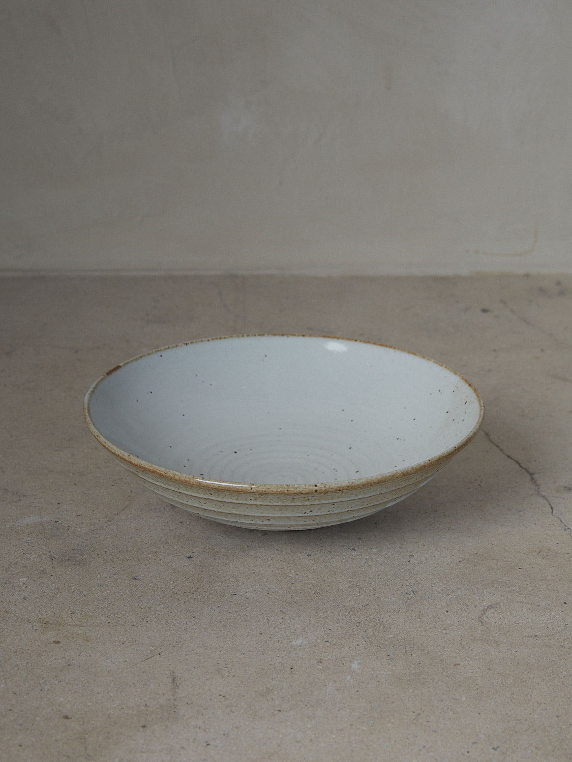 Wide Shinogi Bowl. Limited edition. One-of-a-kind, hand-thrown, footed stoneware bowl with horizontal Japanese Shinogi style ridge pattern on exterior in a creamy white speckle finish. 