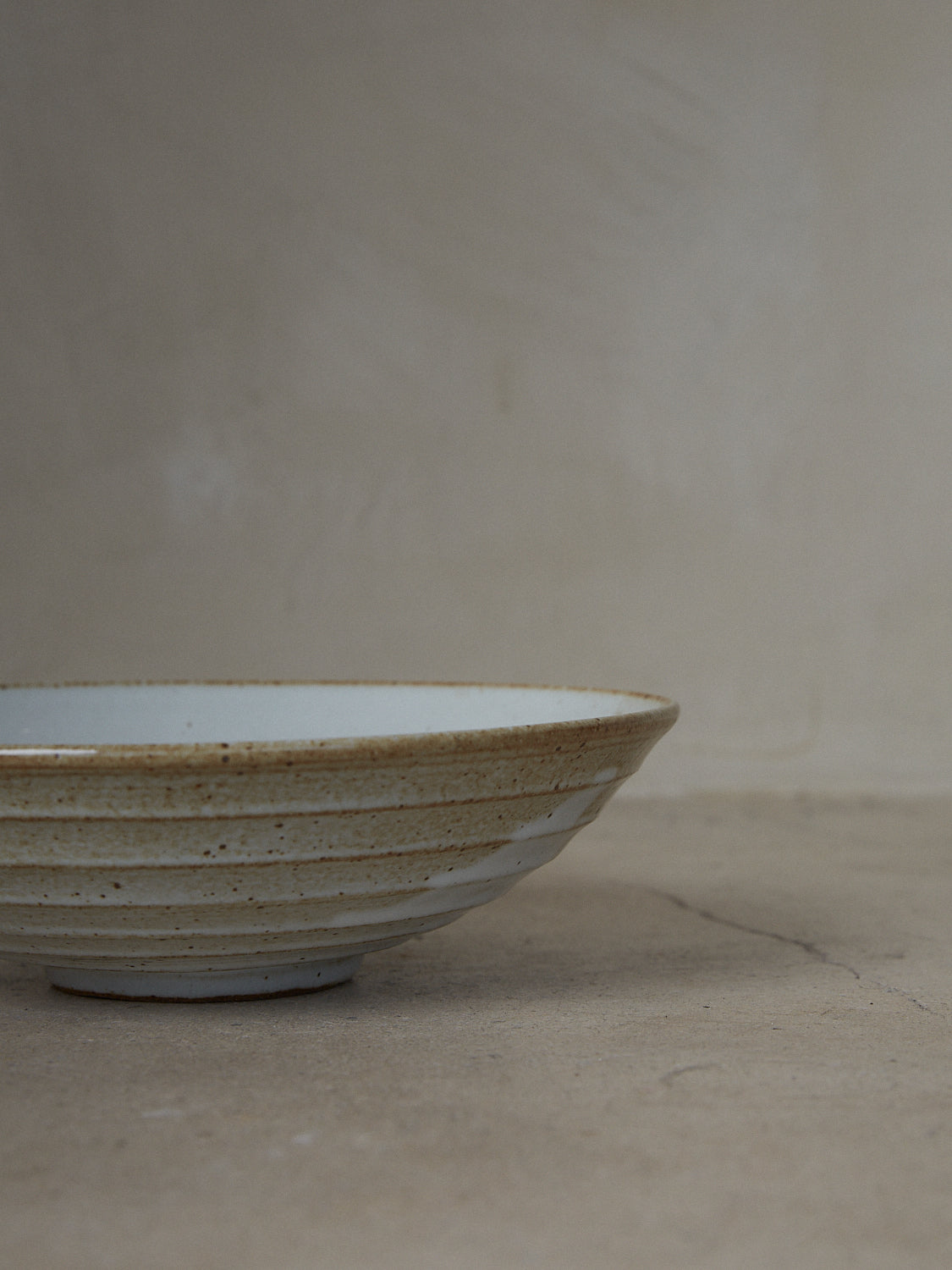 Wide Shinogi Bowl. Limited edition. One-of-a-kind, hand-thrown, footed stoneware bowl with horizontal Japanese Shinogi style ridge pattern on exterior in a creamy white speckle finish. 