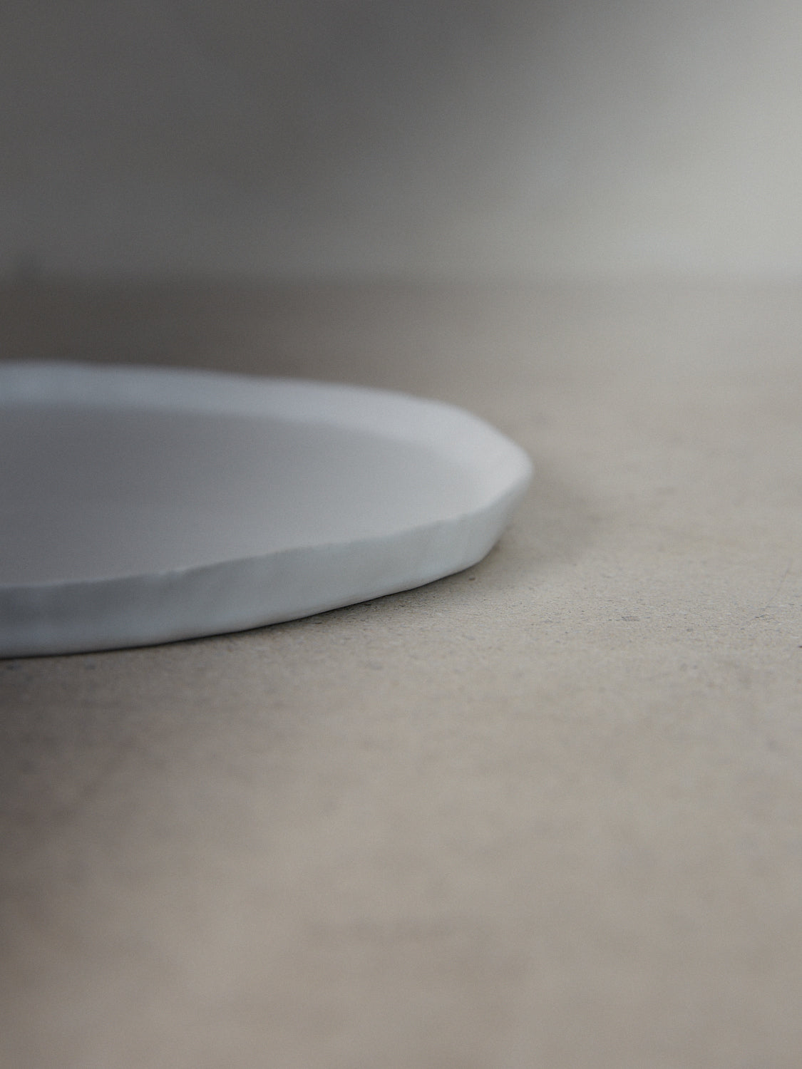 Raw Salad Plate in Ecru. A hand-formed stoneware salad plate recalling the natural world with perfectly imperfect edges in a classic matte white finish.