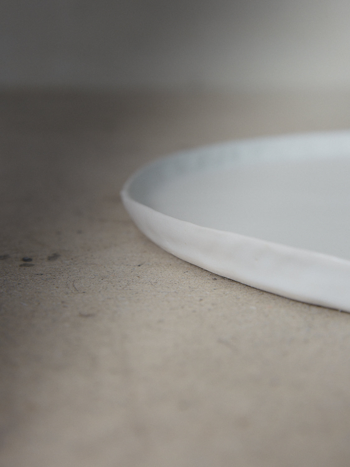 Raw Salad Plate in Ecru. A hand-formed stoneware salad plate recalling the natural world with perfectly imperfect edges in a classic matte white finish.