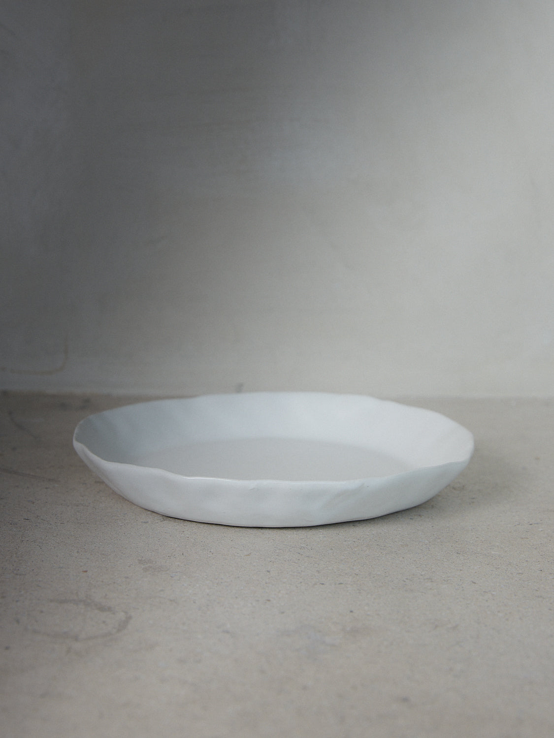 Raw Small Platter. A hand-formed rimmed platter recalling the natural world with perfectly imperfect edges in versatile matte white stoneware. 