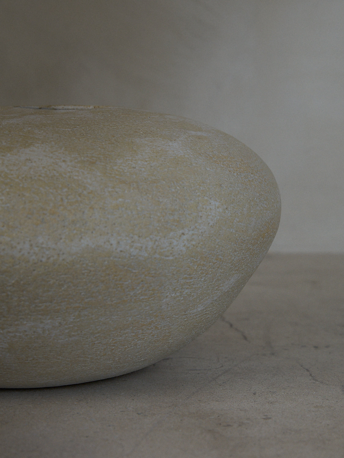 A statement vase inspired by aged river rocks with an irregular oblong shape in a matte stone finish.